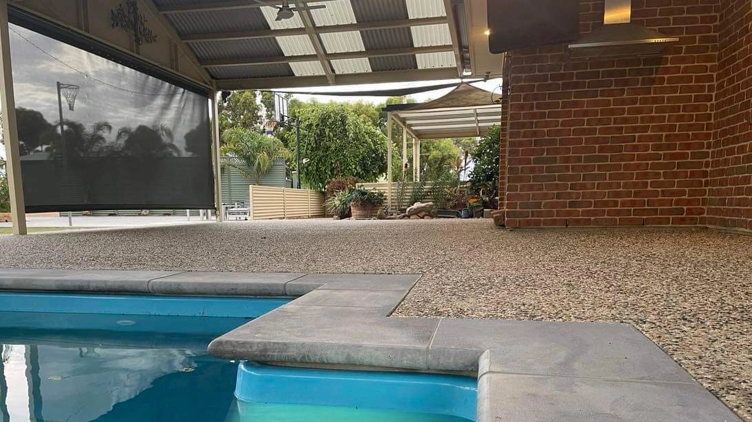 Exposed-Backyard-Concrete-Around-Pool-SpryCrete